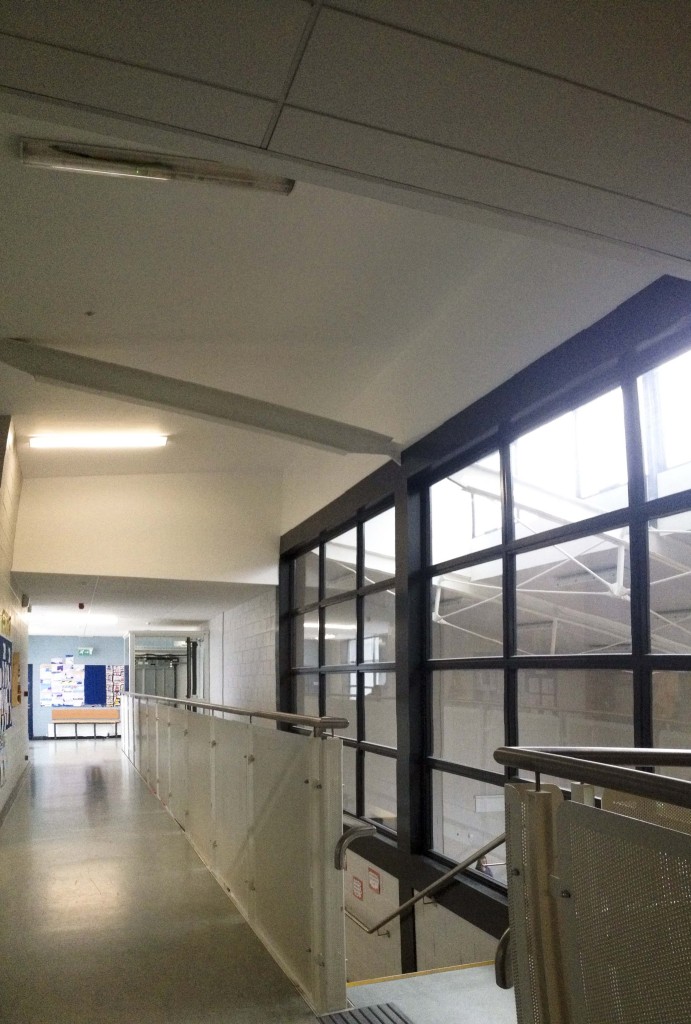 School corridor on first floor showing sports hall on right.
